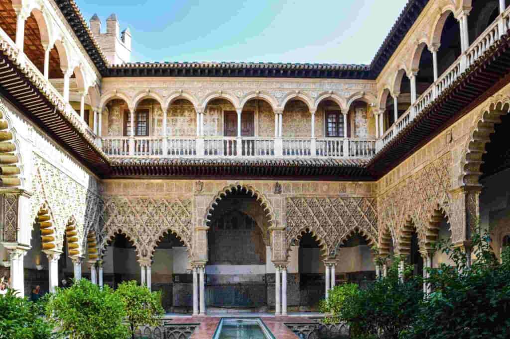 Courtyard of the Royal Alcazar in Seville with arches and gardens
