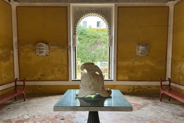 Golden Room in Casa de Pilatos with central sculpture and garden views in the background